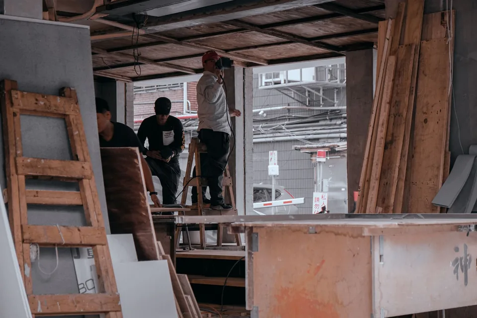 店面骨架施工中，工人在街邊作業
