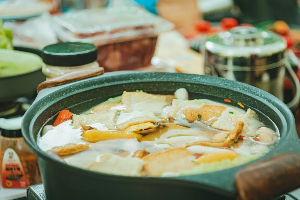 砂鍋內豆腐與配料浸在滾燙湯底裡