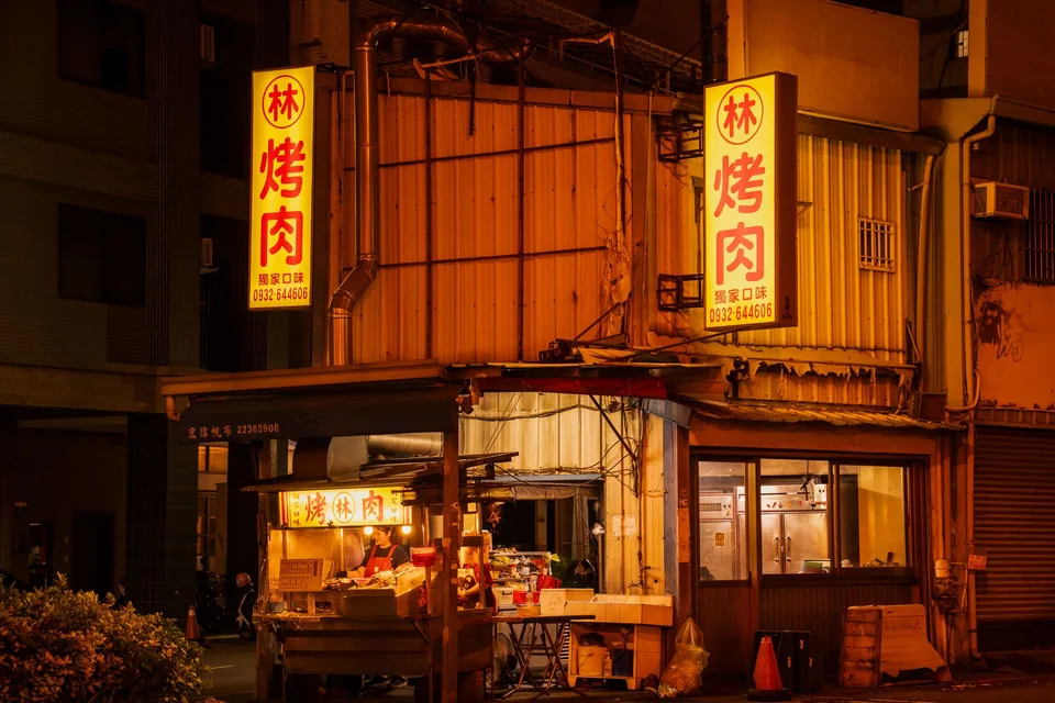 路邊烤肉攤車與後方店面招牌並列